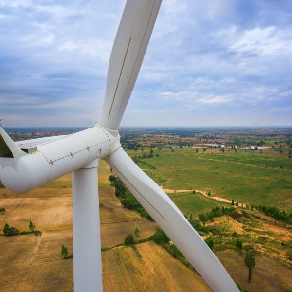 Windkraftanlage von hinten gesehen mit Blick über Felder und Wiesen